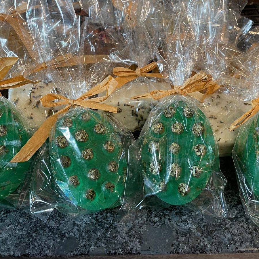 Green oval moringa soaps studded with dried moringa leaf, wrapped and tied